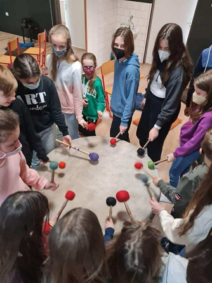 Skupina v kruhu s paličkami a bubnom